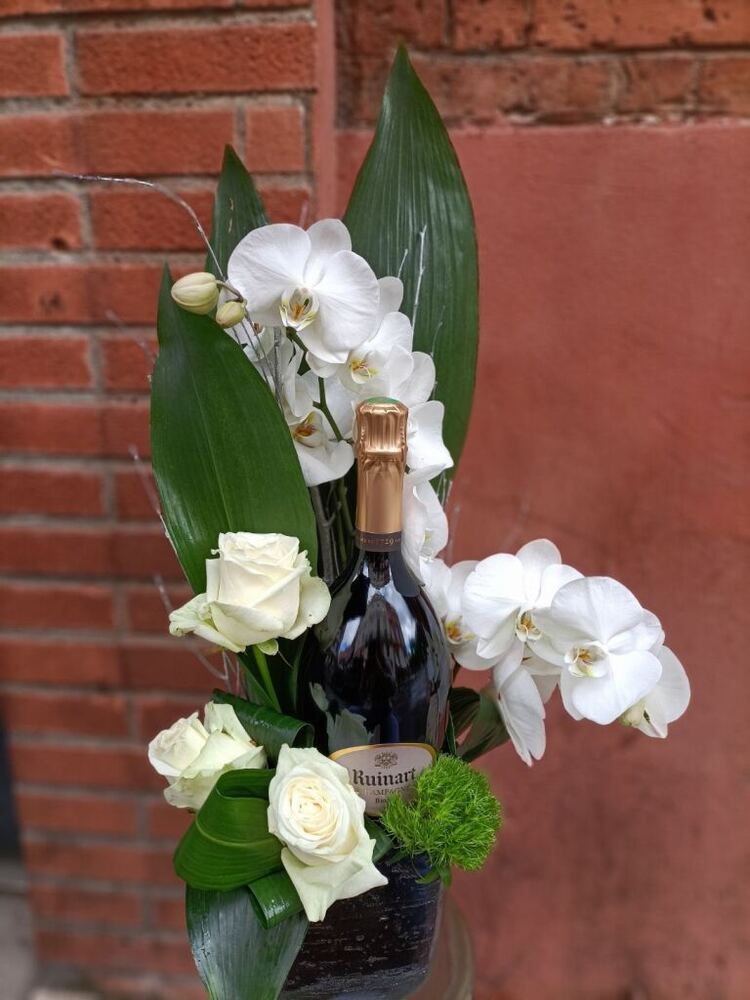 Bouteille de champagne décorée de fleurs blanches